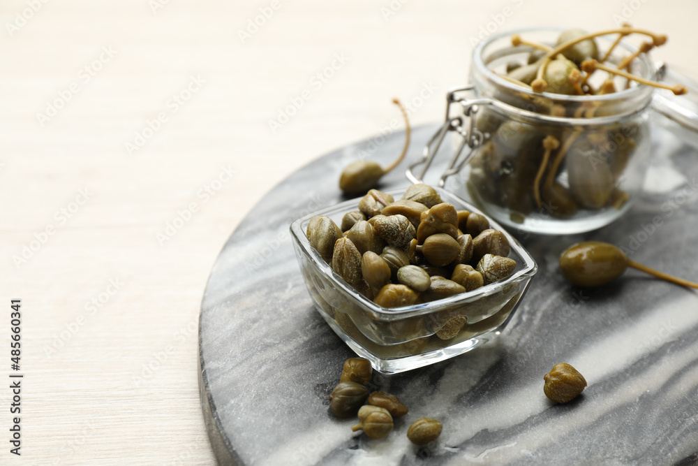 Delicious pickled capers on white wooden table, space for text Delicious pickled capers on white wooden table, space for text