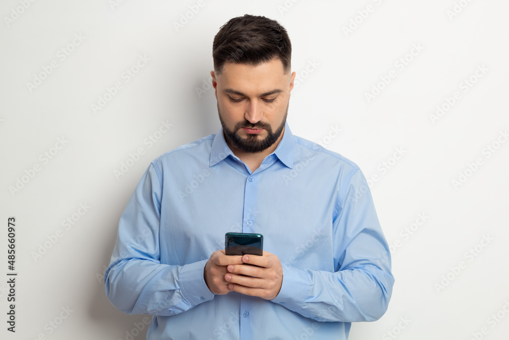 Portrait of a man using a mobile phone, smartphone standing on a white background. Portrait of a man using a mobile phone, smartphone standing on a white background.
