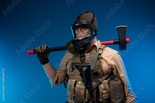 a man in military clothes and a gas mask with a red fire axe on his shoulder