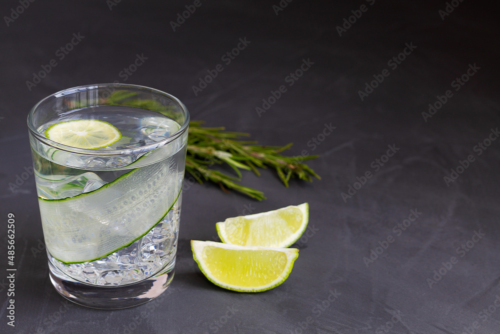 mojito cocktail on black.Cucumber water with lime and rosemary. glass of Homemade flavoured lemonade on the black table. detox water. cold summer lemonade with copy space. mojito cocktail on black.Cucumber water with lime and rosemary. glass of Homemade flavoured lemonade on the black table. detox water. cold summer lemonade with copy space.