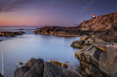 lighthouse on the coast by sunset