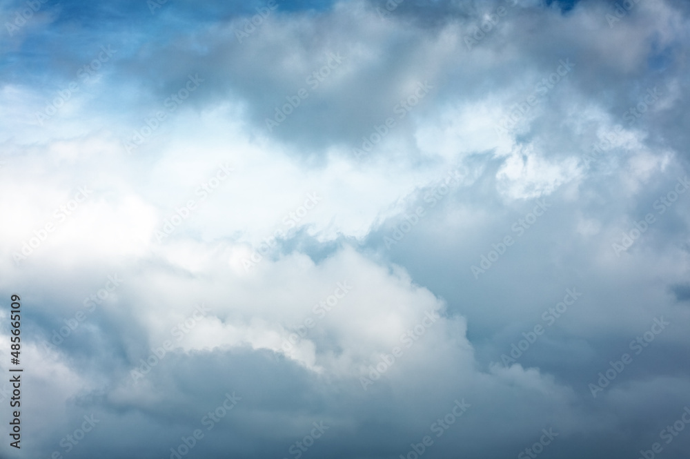 Daytime blue sky Background with white and black cumulus clouds . Dramatic sky overly. Soft focus.