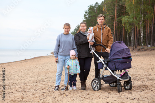 Family with multiple children standing on sandy beach together