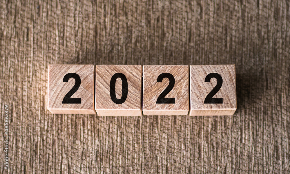 Fototapeta premium Wooden cubes with figures 2022 on wooden background. Vision future concept.