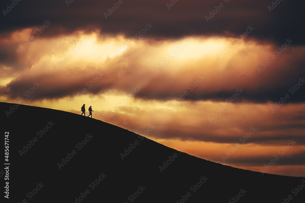 silhouette of people standing on the top of mountain