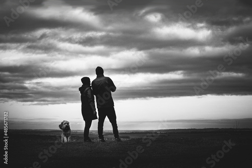 silhouette of people on mountain with dog photo