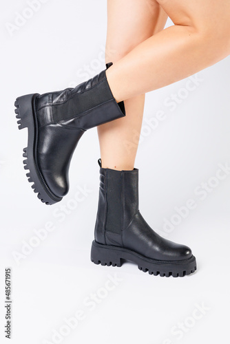 Women's black spring boots made of genuine leather are dressed on bare feet