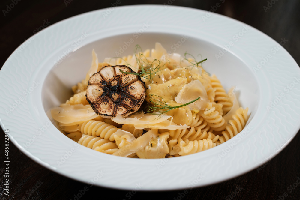 Pasta with herbs. Traditional Italian dish served on restaurant table.