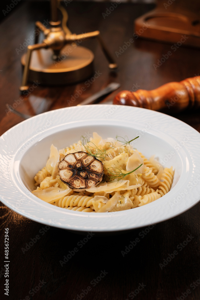 Pasta with cheese and herbs garnished with fried garlic. Traditional Italian dish. Pasta with cheese and herbs garnished with fried garlic. Traditional Italian dish.