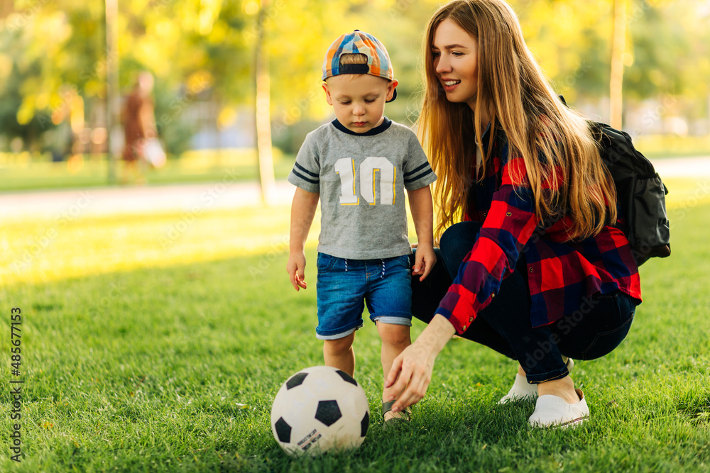 Happy family play football in summer, Mother and son play and run in the park on a beautiful morning Happy family play football in summer, Mother and son play and run in the park on a beautiful morning