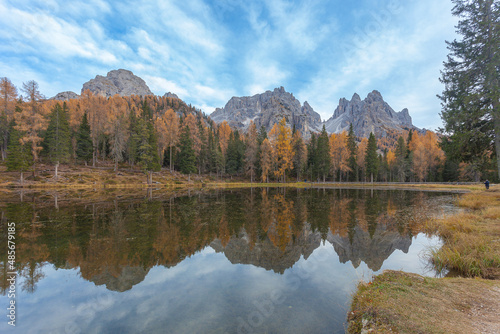Reflection of autumn larches and dolomitic peaks on Lake Antorno, with the Cadini di Misurina in the background, Dolomites, Italy. Popular travel destination