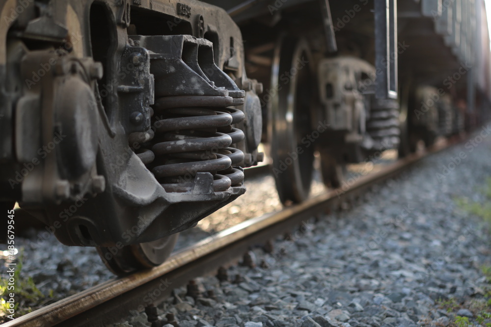 Fototapeta premium Freight train wagon carriage. Locomotive, train in motion, metal wheels background. Railway transportation system. Logistic service, Industrial transporting