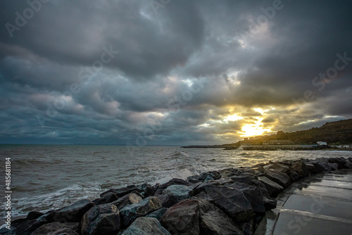 dramatic sky over the black sea with waves, clouds and stones