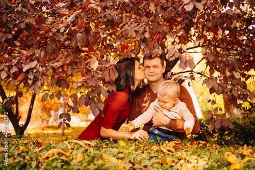 a happy family with a small child on an autumn walk in the park. 