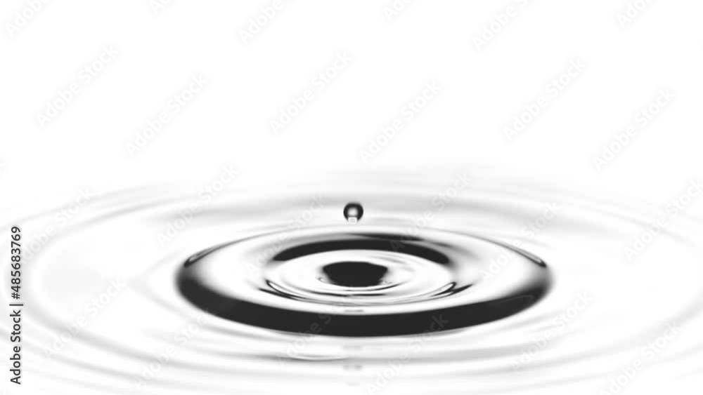 A single drop of water falling into a pool of water in slow motion.