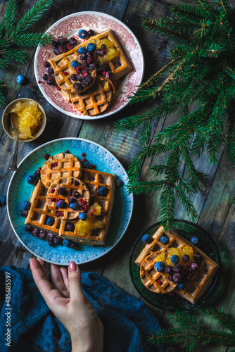 Croissant Waffle or Croffle with srawberry and blueberry sauce served in plate and dark background. Close up, copy space. photo