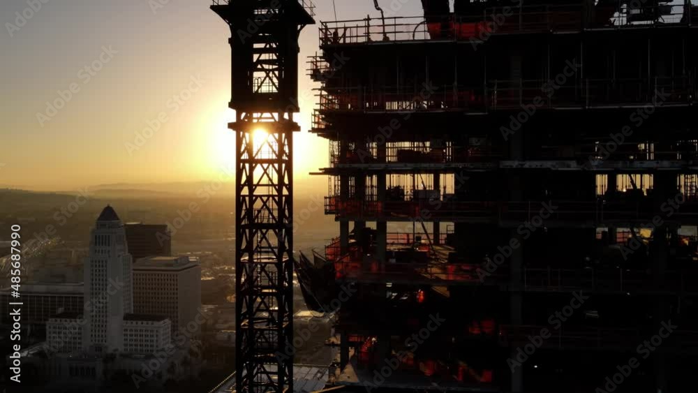 Aerial shot of a new high-rise building under construction at sunrise