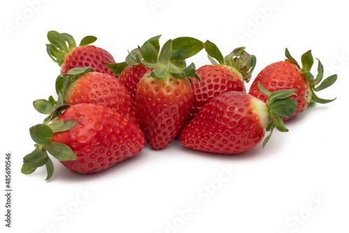 A bunch of whole strawberries with their green leaves isolated on white background.