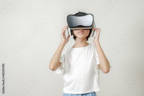 VR application test Asian child girl with virtual reality glasses headset touching air during the VR experience  asia children and learning with virtual reality simulator application test