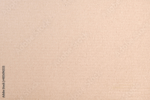 The texture of the surface of brown packaging cardboard for boxes in close-up.