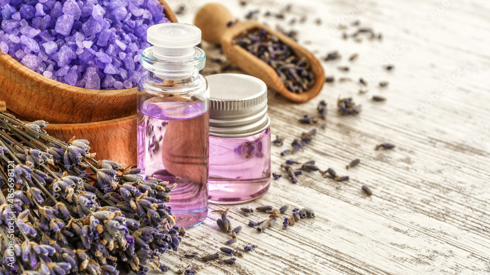 lavender's spa products with dried lavender flowers on a wooden table. Flat lay bath salt and massage oil on wooden background. Skin care, beauty treatment concept. Lavendula oleum lavender's spa products with dried lavender flowers on a wooden table. Flat lay bath salt and massage oil on wooden background. Skin care, beauty treatment concept. Lavendula oleum