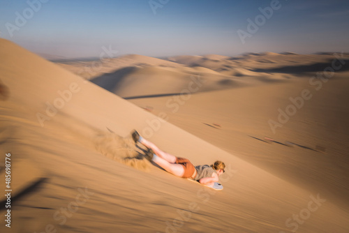 Sand boarding on dunes in the desert at Huacachina, Ica Region, Peru, South America © Matthew