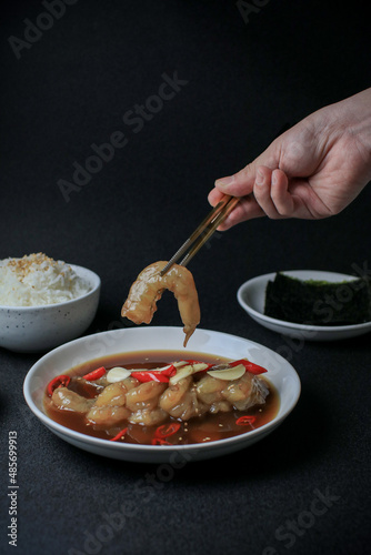 Pickled shrimps (Saewoo-Jang), marinate raw shrimps with chili, garlic and soy sauce on dark background. Korean food.