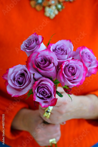 Woman holding a bouquet of purple roses tipped with pink for Valentines Day