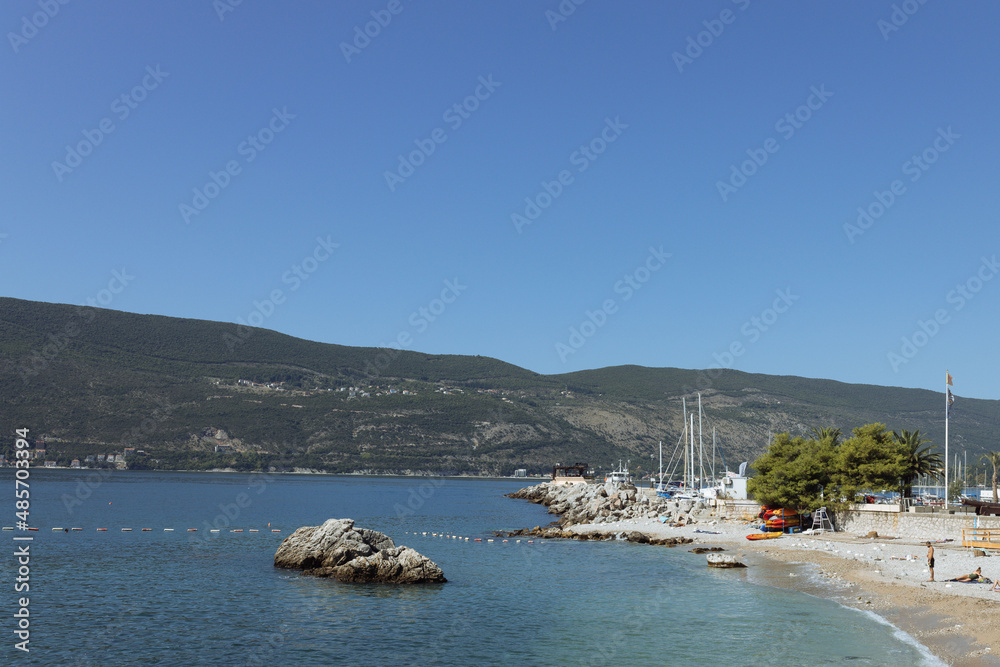 Herceg Novi, Montenegro - 15.09.202:  bathing  people in the Bay of Kotor on the Adriatic sea coastline at sunny day, mediterranean landscape. Famous tourist destination, leisure and weekend concept