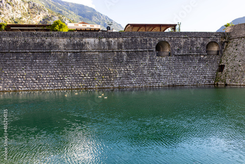   Kotor old wall Fortification in Montenegro. Unesco world heritage. Europe travel site. Vacation concept.  Tourism in adriatic sea. Serbian history of balkans, fort and port buildings.. photo