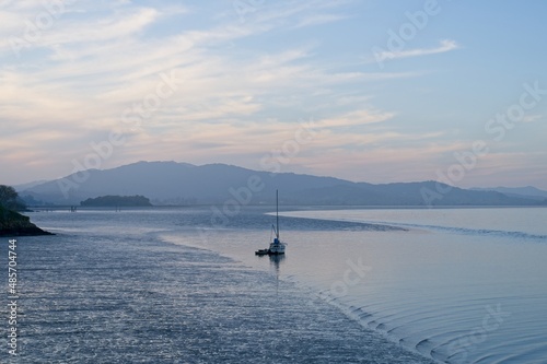 Moody sunset of single boat moored in San Francisco Bay