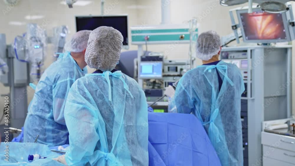 Medical team operating the patient and watching the process at the