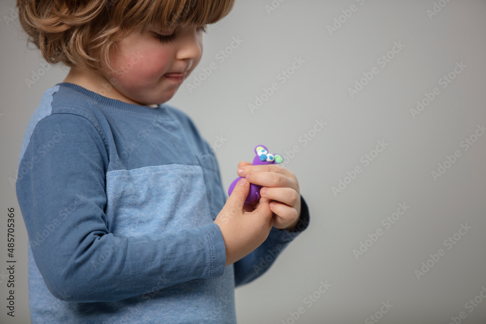 Beautiful toddler sculpt a plasticine and play with a wooden toys at home. Toddler play with a color educational toy and wooden car. Child play at the table in the baby room. Funny baby. Beautiful toddler sculpt a plasticine and play with a wooden toys at home. Toddler play with a color educational toy and wooden car. Child play at the table in the baby room. Funny baby.