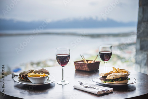 Delicious lunch with red wine at a table at a restaurant with amazing views of the Andes Mountains, Ushuaia, Tierra del Fuego, Patagonia, Argentina, South America