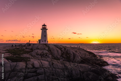 Beautiful sunset at Peggy's Cove Lighthouse with vibrant dynamic color filled with orange and red tones, Halifax, Nova Scotia, Canada