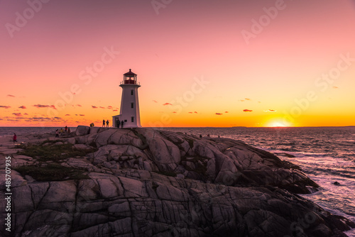 Beautiful sunset at Peggy's Cove Lighthouse with vibrant dynamic color filled with orange and red tones, Halifax, Nova Scotia, Canada