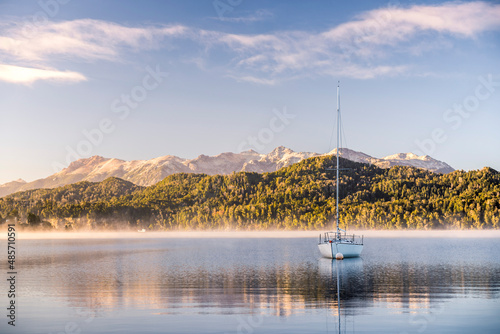 Sailing boat on misty Lake Nahuel Huapi at sunrise, Villa la Angostura, Neuquen, Patagonia, Argentina, South America, background with copy space photo
