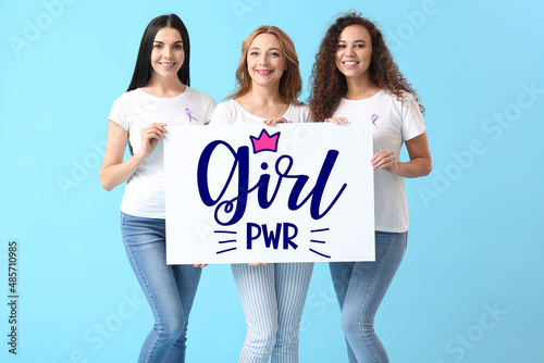 Beautiful women holding poster with text GIRL POWER on color background. International Women's Day celebration