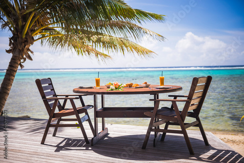 Luxury Villa accommodation with sea views of the tropical Pacific ocean and palm trees with breakfast table set up at the hotel, Muri, Rarotonga, Cook Islands