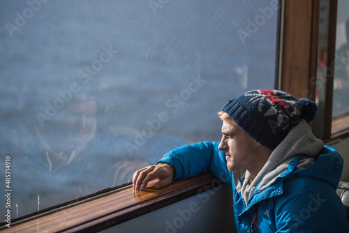 Tourist looking out of a window on a boat in Reykjavik Harbour, Iceland, Europe, background with copy space