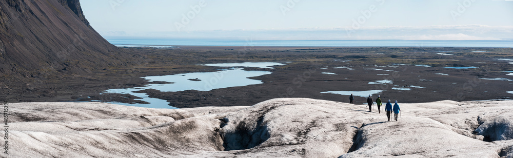 Tourists on vacation in Iceland, walking on Breidamerkurjokull Glacier, Vatnajokull Ice Cap, Europe Tourists on vacation in Iceland, walking on Breidamerkurjokull Glacier, Vatnajokull Ice Cap, Europe