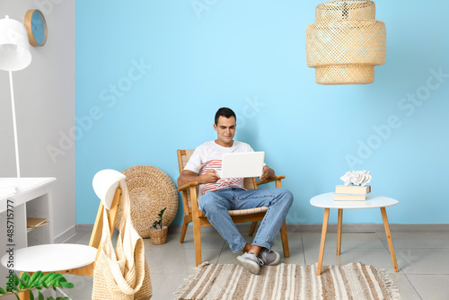Young man using laptop in w...
