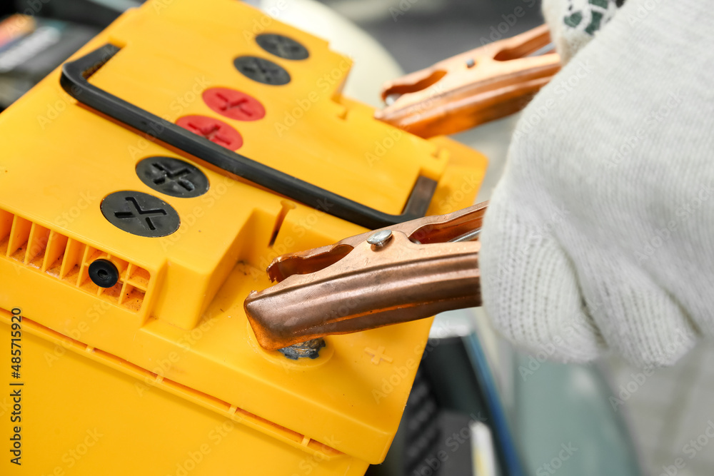 Male mechanic charging car battery, closeup Male mechanic charging car battery, closeup