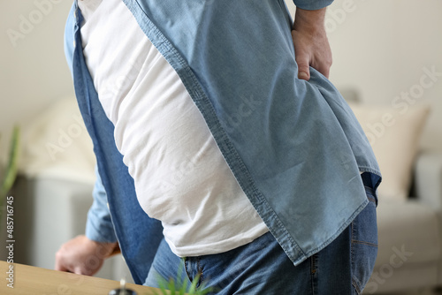 Senior man suffering from back pain at home, closeup