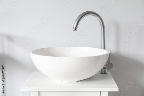 Small table with white sink near light wall