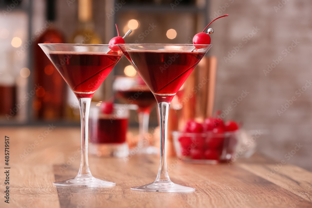 Glasses of tasty Manhattan cocktail on wooden table, closeup Glasses of tasty Manhattan cocktail on wooden table, closeup