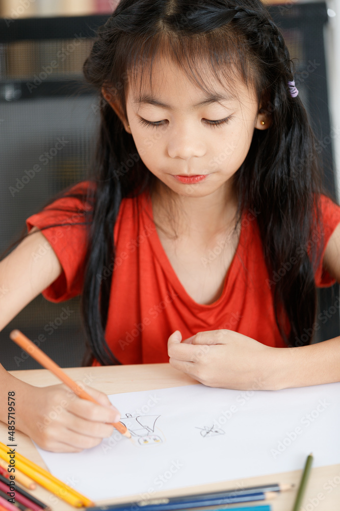 Asian creative young primary school girl artist in casual outfit sitting using color pencil drawing painting picture at home school classroom lesson in living room during pandemic quarantine period Asian creative young primary school girl artist in casual outfit sitting using color pencil drawing painting picture at home school classroom lesson in living room during pandemic quarantine period