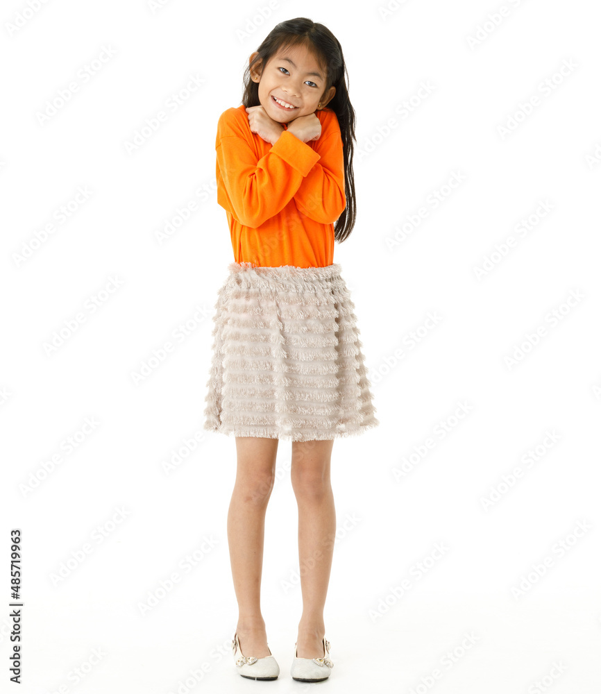 Full body cutout isolated studio shot of Asian young primary schoolgirl model in casual orange shirt and skirt outfit standing on white background Full body cutout isolated studio shot of Asian young primary schoolgirl model in casual orange shirt and skirt outfit standing on white background