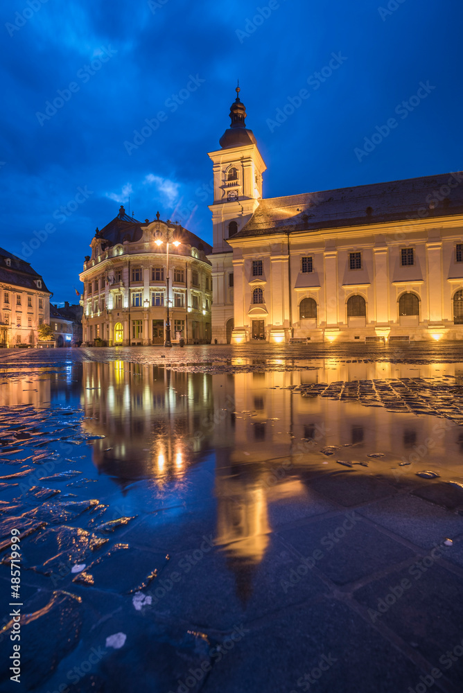 Piata Mare (Great Square) at night, with Sibiu City Hall on left and Sibiu Baroque Jesuit Church on right, Transylvania, Romania