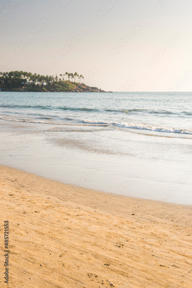 Tropical sandy Palolem Beach on the Goa coast, with pam trees and white sand, India